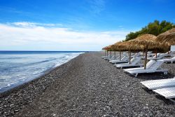Uno scorcio della spiaggia attrezzata di Agios Georgios a Santorini, Grecia. In questo tratto di litorale, molto ampio e fra i più suggestivi, si possono trovare sistemazioni di ogni ...