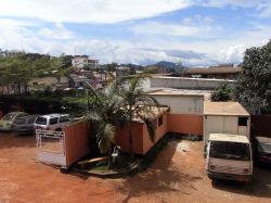 Scorcio di un cortile nel cuore di Yaoundé, Camerun, con auto e pulmini parcheggiati - © StreetVJ / Shutterstock.com