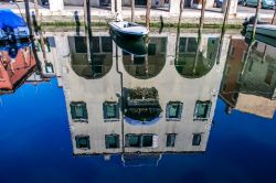 Scorcio fotografico di una strada nei pressi del canale con riflessi sull'acqua a Chioggia, Veneto, Italia.



