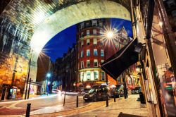 Uno scorcio notturno della cittadina di Newcastle upon Tyne, Inghilterra. Sotto il ponte Tyne, caffé, ristoranti, negozi e taxi.

