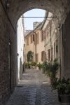 Scorcio panoramico del centro di Recanati, Marche, fotografato da sotto un porticato. Mattoni e ciottoli creano un'atmosfera d'altri tempi.
