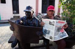 Scultura a Camaguey, Cuba - Un abitante cubano posa per una simpatica fotografia vicino ad una scultura che lo ritrae. Le vie della città ospitano molte opere scultoree di persone sconosciute ...