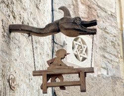Scultura in legno come insegna di una falegnameria a Pezenas, Francia. Sullo sfondo, una stella di David scolpita nel muro. Siamo nel quartiere ebraico della cittadina - © Gary Perkin / ...