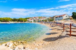 Sdraio e ombrelloni su una spiaggia dell'antica città di Primosten, Croazia. Questa splendida destinazione turistica della costa croata ospita qualcosa come 20 chilometri di spiaggia, ...