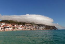 Sesimbra (Portogallo) e la sua spiaggia con una caratteristica formazione nuvolosa in una giornata di sole.