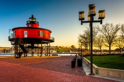 Seven Foot Knoll Lighthouse al tramonto all'Inner Harbor di Baltimora, Maryland. Costruito nel 1855, rappresenta il più antico faro a vite del Maryland. In origine si trovava in cima ...