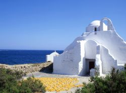 Chiesa bianca di Paros con il Mar Egeo sullo sfondo, Grecia. Ogni angolo di quest'isola, da costa a costa, è disseminato di cappelle bianche che in passato vivevano nella preoccupazione ...