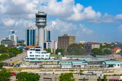 Grattacieli moderni e torre di controllo marittimo a Dar es Salaam, Tanzania - Il contrasto fra vecchio e nuovo è ben rappresentato da questa immagine dove recenti grattacieli in vetro ...