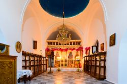 Decorazioni nella chiesa di Panagia Stratolatissa a Kythnos, Grecia. L'iconostasi decorata da icone con ricami e fiori di bouganville all'interno di questo grazioso edificio religioso ...