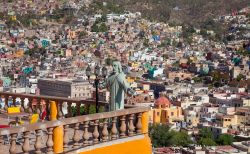 Skyline di Guanajuato, Messico. Gli edifici colorati della città con la statua di Cristo che sovrasta il panorama visto da un balcone.



