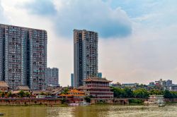 Skyline di Leshan affacciata sul fiume, Cina. Un pittoresco contrasto fra gli edifici di antica costruzione e quelli di epoca moderna con torri e grattacieli.

