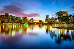 Skyline di Orlando, Florida - I colori del tramonto si riflettono sul lago Eola creando uno skyline ancora più suggestivo: capoluogo della Contea di Orange, Orlando è conosciuta ...
