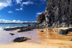 Spagna: spiaggia presso la località di Playa Blanca, nel sud di Lanzarote (Canarie). Le rocce visibili nella foto sono nere perché di origine vulcanica.
