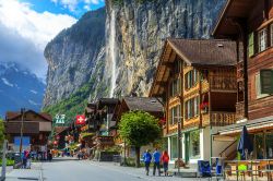 Veduta della principale strada di Lauterbrunnen, Canton Berna, Svizzera, con negozi e hotels. Sullo sfondo, la cascata Staubbach che con il suo salto di quasi 300 metri è la terza più ...