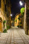 Una strada acciottolata del borgo di Spello in Umbria, fotografata di notte