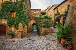 Una spettacolare piazzetta del borgo di Civita Bagnoregio, Lazio. Archetti, cortili, piazze e case medievali e rinascimentali ornate da bifore e portali in piperino: sono solo alcuni degli splendidi ...