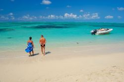 Spiaggia dell'isola dei Cervi, Mauritius - Molti turisti frequentano questo tratto di litorale dalla sabbia bianca e le acque turchesi. In questa immagine, un motoscafo e una coppia intenta ...