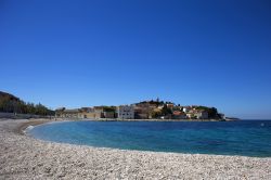 Spiaggia di ciottoli lungo la costa della città di Primosten, Croazia. L'acqua dell'Adriatico lambisce questa pittoresca località della Dalmazia.
