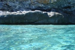 Spiaggia di Mouros a Amorgos, Grecia. Le rocce si tuffano a strapiombo sul mare e le spiagge si diradano. Siamo lungo la costa orientale di quest'isola dell'arcipelago delle Cicladi.

 ...