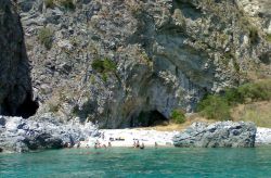 Spiaggia e scogliera di Caminia vicino a Catanzaro, Calabria. Questa breve striscia di sabbia incastonata fra due scogliere che dalla collina cadono a picco sul mare è una delle più ...
