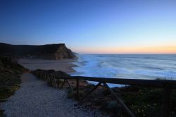 Spiaggia rocciosa di Sao Juliao fotografata al tramonto a Ericeira, Portogallo.


