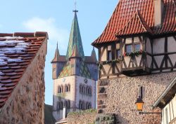 La sagoma della splendida torre della chiesa di Saint-Georges si staglia tra i tetti del borgo di Châtenois, non distante da Kaysersberg, in Francia - foto © LENS-68 / Shutterstock.com ...