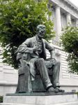 La statua di Abraham Lincoln seduto mentre guarda la City Hall di San Francisco, California.

