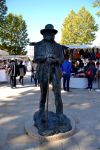 La statua di Cézanne tra le bancarelle del mercato che circonda la Fontaine de la Rotonde ad Aix-en-Provence (Francia).