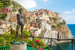 Statua in bronzo di Antonio Puja e il panorama di Manarola. Siamo in Provincia di La Spezia, nelle Cinque Terre della Liguria