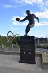 Statua in onore di Dick Reynolds all'Olympic Park di fronte al Melbourne Cricket ground, Australia. Ritrae il celebre calciatore australiano mentre si prepara a calciare la palla - © ...