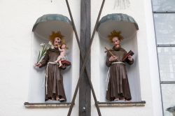 Statuette di monaci nella nicchia di un edificio religioso a Altotting, Germania. Quello di sinistra tiene in braccio il Bambino Gesù mentre l'altro una copia della Bibbia.
