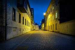 Una strada con pavimentazione a ciottoli nel centro storico di Lund, Svezia, illuminata di notte.

