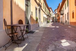 Strada tipica del centro di Alba, Piemonte, Italia. E' il tradizionale ciottolato rosso a caratterizzare la pavimentazione delle vie della città piemontese che ancora oggi conserva ...