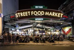 Turisti assaggiano lo street food di Saigon presso il Ben Thanh Market a Ho Chi Minh City, Vietnam - © AsiaTravel / Shutterstock.com
