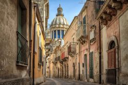 Stretta via di Ragusa, Sicilia, Italia. Un suggestivo scorcio fotografico della città con le vecchie case che si affacciano sulla strada e il duomo della chiesa visibile sullo sfondo.


 ...