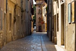 Strette viuzze nel centro storico di Porec, Croazia. Edifici e palazzi si affacciano sulle viuzze acciottolate nel centro cittadino - © Alexey Pustoshilov / Shutterstock.com