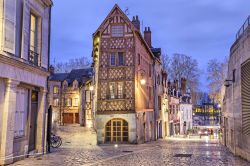 Un suggestivo scorcio del centro storico di Orléans by night: una strada pavimentata con blocchi di pietra e una casa ad angolo a graticcio (Francia).

