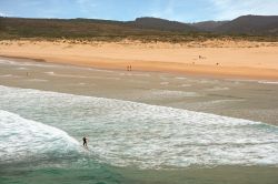 Surfer con la tavola a Praia da Bordeira, Carrapateira, Algarve. Grazioso e tranquillo villaggio composto da poche case, Carrapateira è una vera e propria mecca per gli appassionati del ...