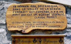 La targa dedicata a Monet presso il ponte romanico di Dolceacqua: da qui il pittore immortalò su tela il paesaggio con il Castello Doria e il borgo ligure © wikipedia