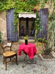 Tavolino e sedia di fronte alla finestra di un ristorante nel centro di Monpazier, Francia - © Cmspic / Shutterstock.com