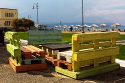 Tavolo e sedie multicolori fatte con pallets in una strada di Corinto, Grecia.

