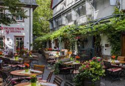 Terrazza all'aperto con sedie e tavoli in legno al Rudesheimer Schloss nell'omonima città tedesca, Assia  - © Daan Kloeg / Shutterstock.com