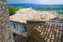 Tetti delle case di Gordes, Francia - Tegole in terracotta ricoprono i tetti delle abitazioni in pietra beige del villaggio arroccato sul bordo meridionale dell'alto Plateau de Vaucluse ...