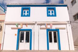 Tipica architettura di un edificio visto dall'esterno nella città di Olhao, Portogallo. Case basse dipinte di bianco, dalle forme squadrate e addossate fra loro, rendono Olhao molto ...