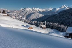Tipiche capanne in legno nelle montagne tirolesi a Arzl im Pitztal, Austria, immerse dalla neve.
