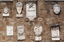 Tipiche decorazioni su edifici a Sovana, Toscana. Alcuni stemmi adornano la facciata di questo palazzo del centro storico di Sovana - © Claudio Giovanni Colombo / Shutterstock.com