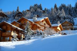 Tipici chalet alpini in legno in una giornata di sole a Meribel, Savoia, Francia.
