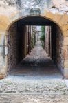 Un tipico vicoletto con arcata nel centro storico di Monpazier, regione della Dordogna, Francia.

