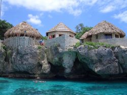 Tradizionali abitazioni con il tetto in paglia lungo la costa di Negril, Giamaica.



