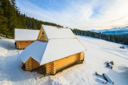 Tradizionali case di legno a Bukowina Tatrzanska con paesaggio innevato, Polonia. 
